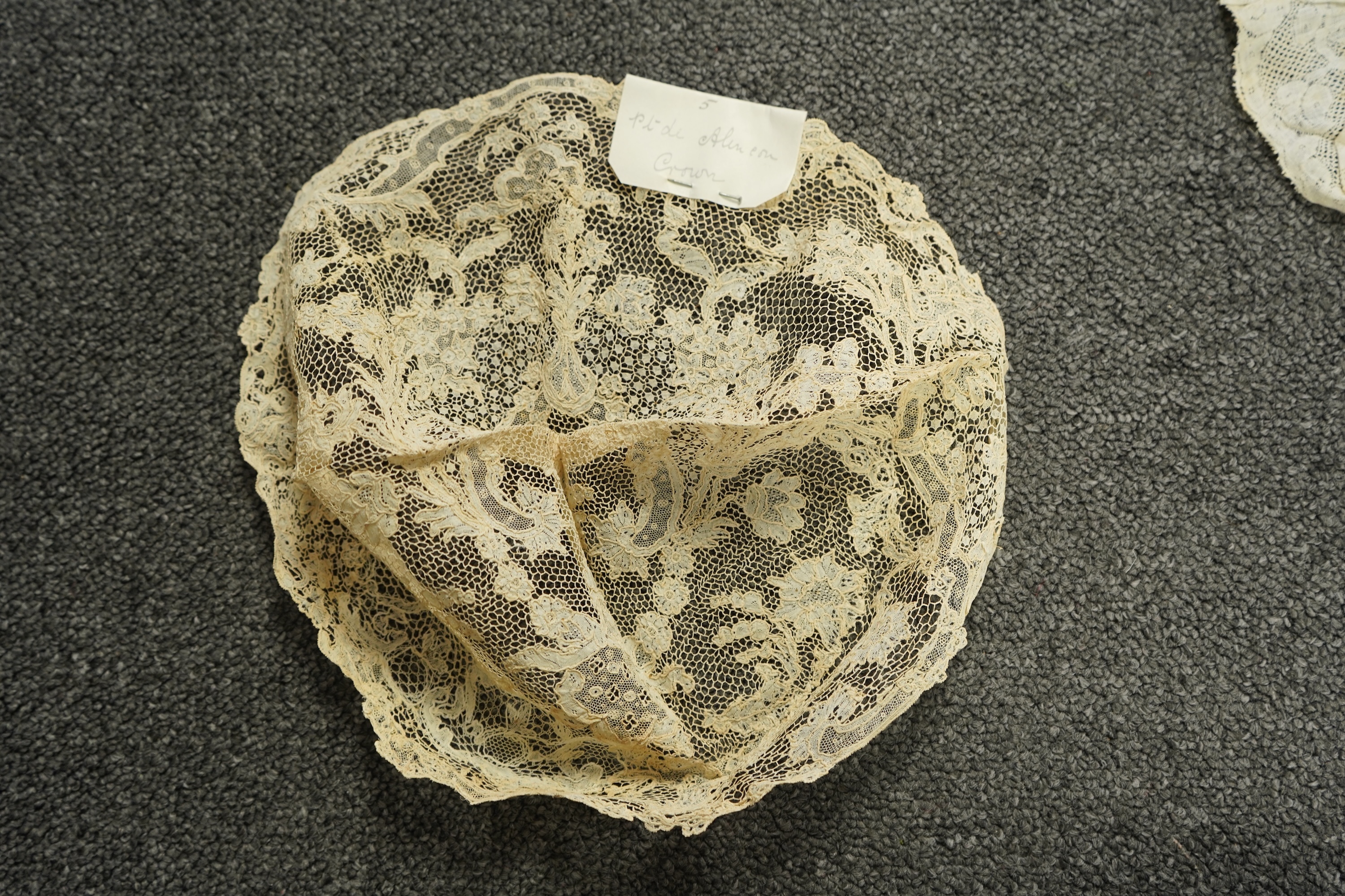 A collection of 18th century needle and bobbin lace. Including an 18th century wide pair of joined Valenciennes lace lappets, a similar 18th century cap back, an ornately worked Point de Alencon cap crown and another sim